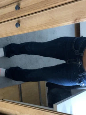 Mörkblå bootcut jeans med kontrastsömmar från Ginatricot - Säljer ett par mörkblå jeans med bootcut passform och tydliga vita kontrastsömmar som ser väldigt lika miss me jeans! med låg midja och snygga detaljer på bakfickorna. Jeansen är i stretchigt denim som sitter skönt och formar sig efter kroppen