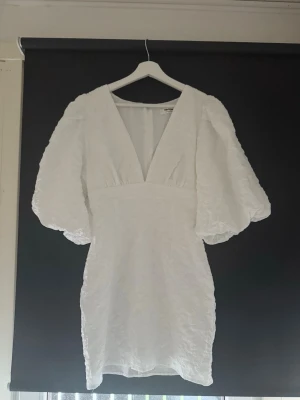 Vit kortklänning från Showpo - Säljer min studentklänning från showpo! Supersnygg vit kortklänning med puffiga kortärmar och djup v-ringning. Nypris var 1000 kronor men säljer den för 800 😍😍☺️