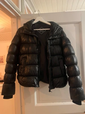 Svart pufferjacka från Superdry XP-D - Jacka från Superdry! Köptes för 1500kr men denna har några små ”hål/upp rivningar”/defekter som syns på bilderna, därav mitt pris! Annars är har den inga ”fel” alls! Supervarm och super skön! Populär modell, storleken syns ej men har för mig att det är storlek 38, men passar även 36 då jag har det i vanliga fall!🙌🏼🥰