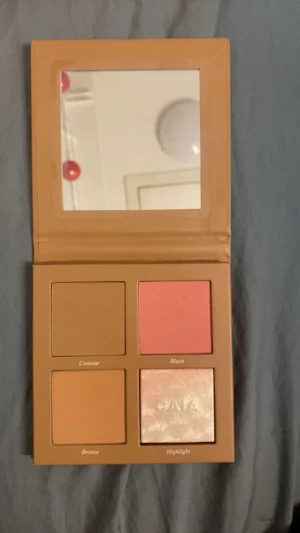 CAIA Face Palette Sassy - !helt ny! Snygg ansiktspalett från CAIA i färgen Sassy med fyra olika puder: contour i matt brun, blush i rosa, bronzer i varm beige och highlighter i skimrande silver färg. 
