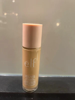 elf halo glow  - pris kan diskuteras !! säljer då den inte kommer till användning 🩷🩷🩷Glow booster i flytande form från e.l.f. i nyansen Fair/Light (Shade 2). Kommer i en genomskinlig glasflaska med ljusrosa lock. Ger huden en strålande finish och kan användas som bas eller highlighter. Perfekt för dig som vill ha en naturlig glow.