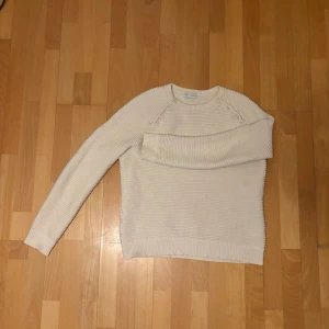 stickad tröja - Säljer en ljusbeige stickad tröja från Essentiel med ribbad struktur och rund hals. Tröjan gör en automatisk bredaxlad och är hyfsad lång nere på tröjan. Vid övriga frågor kom dm.