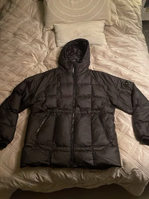  C.P. Company DD Shell Puffer Jacket - Säljer min svarta DD Shell dunjacka från C.P. Company för jag fick en ny jacka i jul. Jackan är loose fit och har ett quiltat mönster samt den ikoniska loggan på ärmen. Måste säga att det är den absolut varmaste och skönaste jackan jag nånsin haft och använd kanske 3/4 gånger. Vid frågor eller andra tankar är det självklart bara att skriva. Priset är även diskuterbart. /BergstenCloset