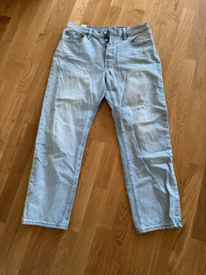 Levi's 501 ljusa jeans W31 L30 - Säljer ett par klassiska Levi's 501 jeans i ljusblå tvätt. Modellen har rak passform.. Jeansen är tillverkade i bomull och har den ikoniska läderpatchen bak samt röd Levi's-tag på bakfickan.