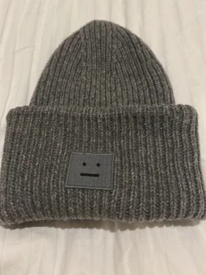 Acne mössa  - En mörkgrå acne mössa one size. Bra skick perfekt till vintern 