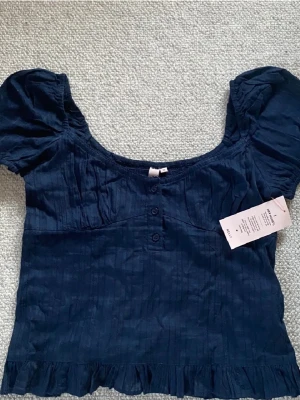 Mörkblå blus med puffärm från Nelly - Säljer en mörkblå blus från Nelly💗💗 Så fin, helt nytt skick med prislapp kvar! ❤️ pris går att diskutera!