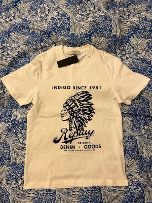 Replay t-shirt - Populär vit t-shirt från Replay med stort tryck framtill. Inköpt i butik i somras och inte används en enda gång därmed lappen kvar. Storlek S