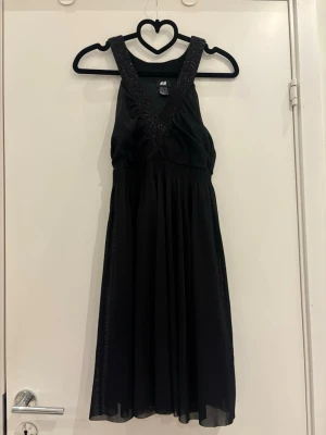 Nyårsklänning - Svart klänning med ”resår” i midjan och glitter, perfekt till nyår!✨