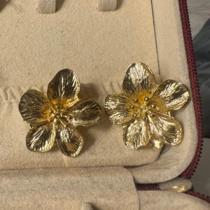 Guldiga blomformade örhängen - Säljer dessa jätte snygga örhängen i form av blommor i guldig metall. Perfekta för dig som vill ha ett statement-smycke med cool blomkänsla!!💘