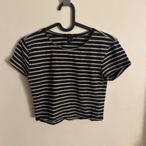 Randig croppad topp från Atmosphere - Säljer en svart och vit randig croppad topp från Atmosphere i storlek 36. Toppen har rund halsringning och korta ärmar, perfekt för dig som gillar en chill och enkel stil. Materialet är mjukt och känns skönt mot huden.