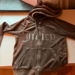 Brun velour hoodie Juicy Couture XS - Säljer en brun velour hoodie från Juicy Couture i storlek XS💕. Sälja pga att jag inte andvänder längre🥰. Den är som en magtröja ungefär. Dock så har plagget några defekter som ni ser på sista bilden💕💕. Ställ gärna frågor om plagget om det behövs❤️