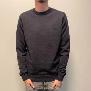  Lacoste tröja - Snygg mörkgrå tröja från Lacoste. Den är använd 1-2 gånger och mycket fint scicka, köptes för 1200