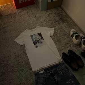Vit T-shirt  - Säljer denna snygga T-shirt med ett svart- vit vintage tryck av Marilyn Monroe på framsidan. Passar perfekt till ett par snygga jeans och en full zip nu till hösten. Klassisk passform med korta armar och u- ringning. 