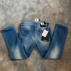 Helt nya handpicked jeans  - Snygga blå jeans från Moser Project i storlek 31. Jeansen har en klassisk femficksdesign, raka ben och coola slitningar framtill. Tillverkade i mjukt denim med naturlig indigo-färgning. Perfekta för dig som gillar en stilren look. Ny pris 3000kr