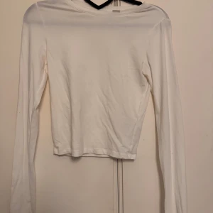 Vit långärmad topp från H&M Divided - En basic vit långärmad topp från H&M Divided. Modellen är enkel med rund halsringning och rak passform.