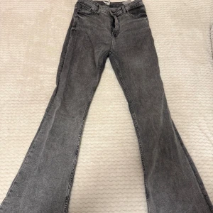 Grå bootcut jeans från Bershka - Snygga grå jeans från Bershka med bootcut i storlek 38.