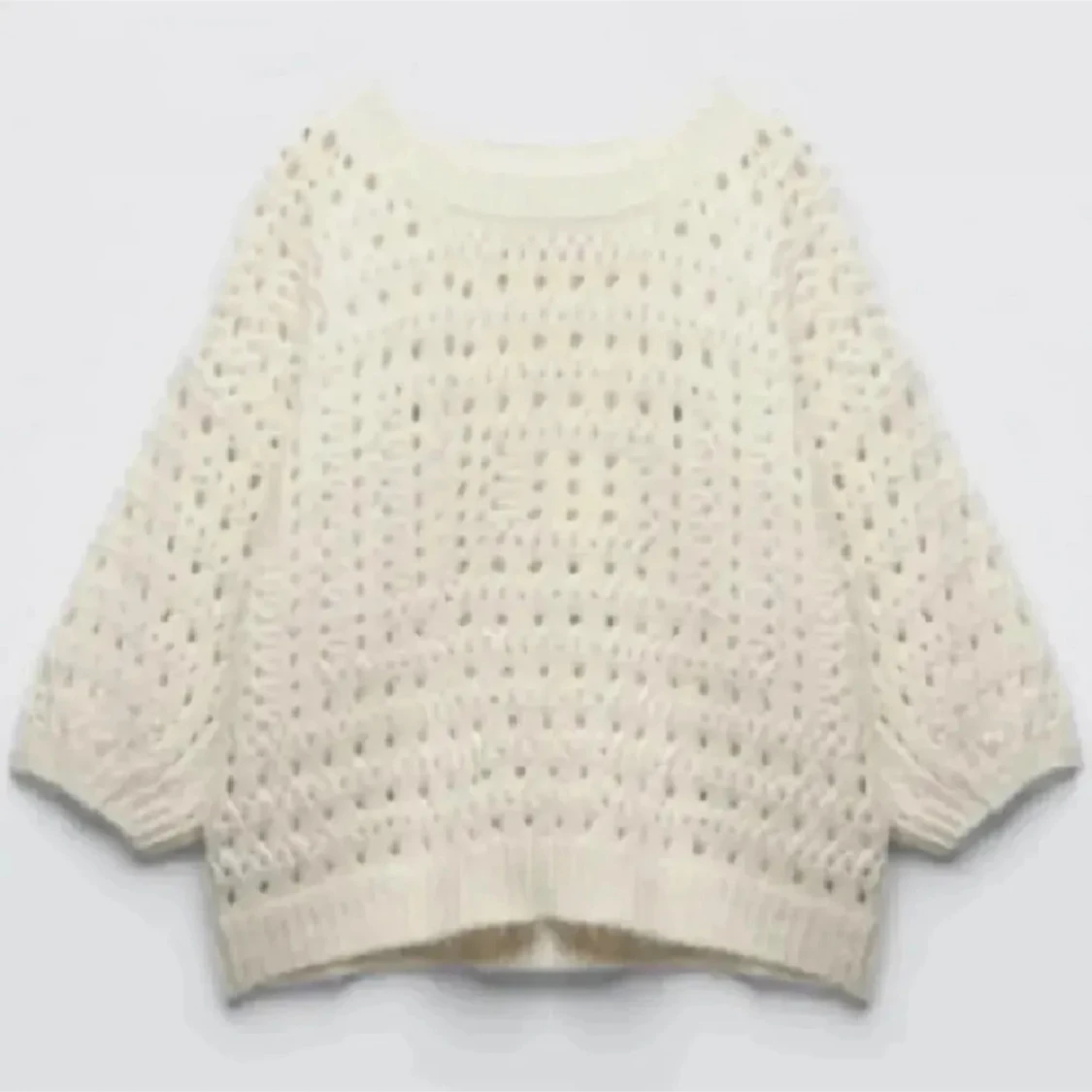 Vit stickad tröja med hålmönster