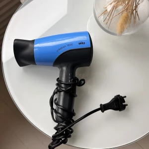 Braun Création 1600 hårfön - Kraftfull hårfön Braun Création 1600 i blått och svart. Utrustad med avtagbart munstycke och två hastighetsinställningar. Sladden och kontakten är i gott skick, och inga synliga defekter eller större slitage. 