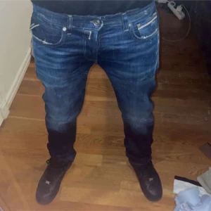 Replay Ice Blast blå jeans - Säljer ett par Replay Ice Blast jeans i klassisk blå tvätt med snygga slitningar och kontrastsömmar. Jeansen har raka ben, fem fickor och tydliga Replay-detaljer på bakfickorna. Materialet är robust denim som sitter skönt och ger en cool look. Pris kan inte diskuteras då orginal priset är 1500 och deme helt oanvända 