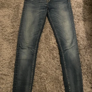 Tiger of Sweden skinny jeans blå - Snygga blå jeans från Tiger of Sweden med klassisk femficksdesign och skinny fit. Jeansen har en mörk tvätt med ljusa slitningar och är tillverkade i stretchig denim för en tight passform. Perfekta för dig som gillar en stilren och modern look.