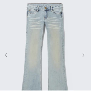 Weekday jeans  - Snygga ljusblå jeans med bootcut-modell och slitna detaljer framtill. Jeansen har klassisk femficksdesign, knapp och dragkedja i gylfen. Perfekta för en avslappnad och trendig look. Använd några enstaka gånger men i fint skick! 
