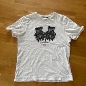 Vit t-shirt Closure London XS - Vit t-shirt från Closure London i storlek XS med tryck av två svarta nallebjörnar framtill. Väldigt stilren och passar till alla outfits.