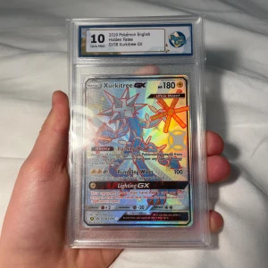  Xurkitree Gx Pokémon kort psa10 rauk10 - Samlarobjekt! En grymt snygg Xurkitree GX-kort från Hidden Fates, graderad till Gem Mint 10. Perfekt för Pokémon-fans och samlare som vill ha något unikt och exklusivt i sin samling. Kortet har en cool holo-effekt och är i toppskick.