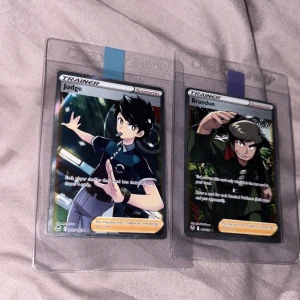 Pokémon Trainer Cards: Judge & Brandon - Två coola Pokémon Trainer-kort: Judge och Brandon! Perfekta för dig som vill boosta din samling eller spela med vänner. Holografiska och i skyddande plastfickor – ett måste för alla Pokémon-fans och samlare.
