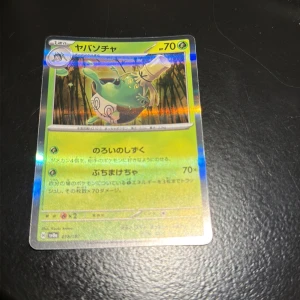 ヤバンチャ (Yabanchya) - Cool och glittrande japansk Pokémon-kort med unikt motiv och färgstark design. Perfekt för samlare och fans som vill ha något speciellt i sin samling. Kortet har 70 HP och är i fint skick, redo att boosta din Pokémon-upplevelse!