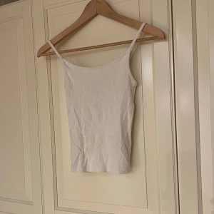 Vit ribbad linne  - Vit ribbad linne med smala axelband. Använt enstaka gång. 