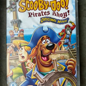 Scooby doo pirates ohoy - Följ med Scooby-Doo och gänget på ett spännande äventyr i Bermuda-triangeln i filmen Scooby-Doo! Pirates Ahoy! Denna DVD innehåller en fartfylld berättelse med pirater, spöken och mysterier som hela familjen kan njuta av.  Finns på språk: Engelska  OBS!! skivorna är begagnade så det kan förekomma repor/hairlines på skivorna, men då jag kollar igenom alla filmer jag säljer garanterar jag att alla funkar felfritt om inget annat står! :)