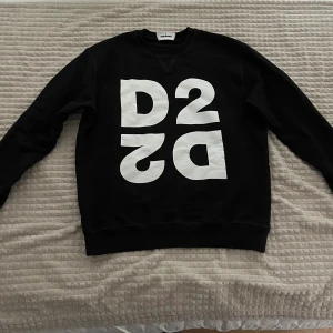 Svart sweatshirt från Dsquared2 - Svart sweatshirt från Dsquared2 med stor vit D2-print framtill. Tröjan har rund halsringning, långa ärmar och en klassisk passform. Pris kan diskuteras 