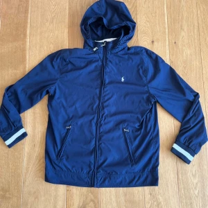 Raplh Lauren windbreaker - Tjena säljer denna riktigt snygga raplh lauren windbreaker i storlek M. Ingen defekt på jackan och luvan går även att stoppa in. Ny pris 2500 mitt pris 700 Hör av er vid minsta lilla frågor!