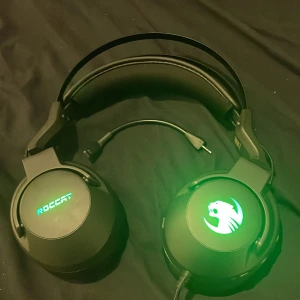 Roccat Elo - Roccat Elo gaming headset med LED-belysning och avtagbar mikrofon. Over-ear design med mjuka kuddar för komfort vid långa spelsessioner. Headsetet är i mycket gott skick utan synligt slitage. Perfekt för gaming och kommunikation.