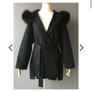 Fur Stockholm Kappa svart - Nästan ny kappa från Fur Stockholm, använd en gång men har tappat bort midjebältet, den har just nu ett annat svart midjebälte så man ser inte så stor skillnad. Storlek S och fin pälsluva! Har ni frågor så bara skriv! Köpt för 2199kr förra året.