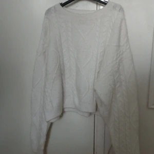 Vit stickad tröja från BikBok XL - Mysig vit stickad tröja från BikBok i storlek XL. Tröjan har ett klassiskt flätmönster, rund halsringning och långa ärmar. Perfekt för lager-på-lager och chill höst- och vinterstil.