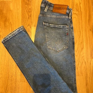 Blåa Replay jeans slitna med skinny fit - Säljer ett par blå jeans från Replay med Lite sköna slitningar där fram Storlek w28 l32. Mycket bra skick använda fåtal gånger. 