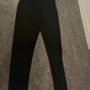 Svarta tighta leggings - Svarta leggings med elastisk midja och smal passform. Mjukt och stretchigt material som sitter bekvämt mot kroppen. Perfekta för en avslappnad stil eller till träning.