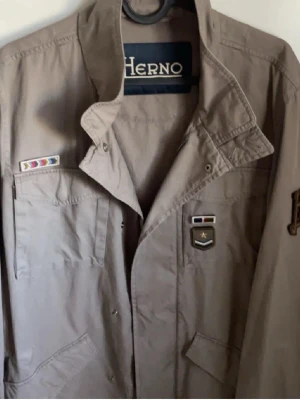 Herno feild jacka  - Väldigt go Herno feild jacka som funkar året runt.  Använd få gånger och har så bra skick de går att ha på ett använt plagg. Inga defekter, och patcharna på jackan kan man ta av.