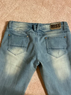 Blå bootcut jeans  - Snygga ljusblå bootcut jeans! Några små defekter men ingen som påverkar funktionen, se bilder innan köp! Midjemått ca 42 cm och Innebenslängd ca 80 cm