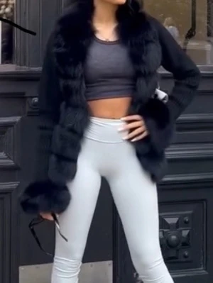 Svart päls kappa  - Säljer en svart pälskappa med bred krage och stora fluffiga detaljer vid ärmslut och längs framkanten. Västen har en lyxig look och är perfekt för att höja din outfit. Materialet är päls och stickad textil, och modellen är loose fit med öppen front.