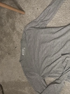 Grå tröja från weekday  - Helt vanlig tröja, lite kortare så den går väl precis under naveln, tunnt material men skönt. Använd 1 gång 