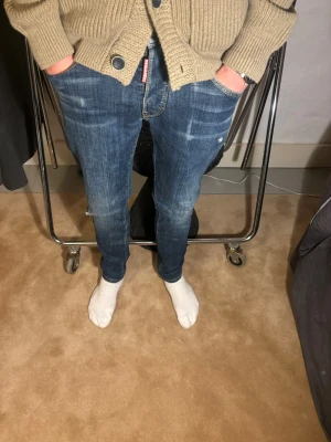 Dsquared2 jeans - Snygga blå jeans från Dsquared2 med klassisk straight fit och coola slitningar. Jeansen har fem fickor, gul kontrastsöm och Dsquared2-logga på både bakficka och framficka. Materialet är robust denim och passformen är normal, perfekt för en chill och stilren look. Modellen på bilden är 179cm lång. Storlek S, nytt pris 3000kr mitt pris 249kr✅ av dig vid funderingar !📩
