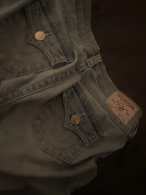 Ljusblå true religion jeans med bootcut - Säljer mina true religion jeans priset kan diskuteras så skriv för intresse de är i storlek w25 i modellen joey low weist bootcut,slitna längst ner men true religion brukar har långa jeans så man kan vika upp den delen så är de inget som syns💕 dom är annars som nya.