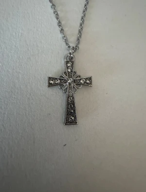 Silverhalsband kors med silverstenar  - Perfekta julklappen 🌲  Säljer smycken som skapats som hobby av mig och dottern.   Halskedjor är 50cm.  Bilder på berlock kan vara missvisande så är det viktigt så fråga gärna om mått 🌹  Smycken är inte av äkta guld/silver .   Inga bud godtas då priserna är så billiga❤️