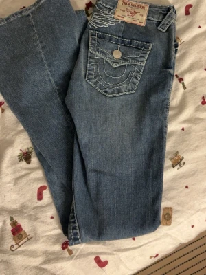 True Religion jeans  - Säljer ett par blå jeans från True Religion med bootcut passform. Dessa har aldrig kommit till användning. Storlek 25. köpta för 1700🤗