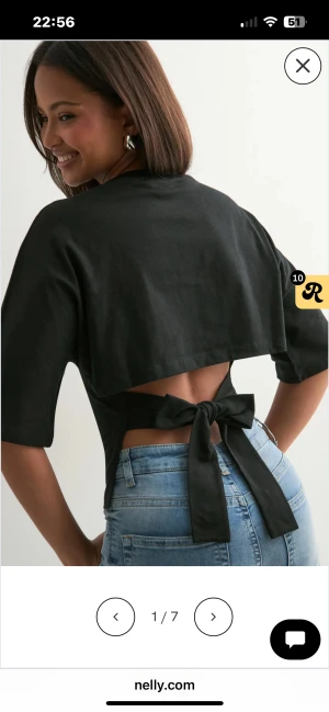 Svart croppad topp med knyt från Nelly - Säljer en svart croppad topp från Nelly med öppen rygg och breda knytband som knyts i en rosett bak. Används 1 gång 