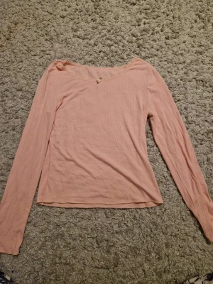 Rosa tröja  - Rosa långärmad tröja med en liten ros i mitten storlek S/M