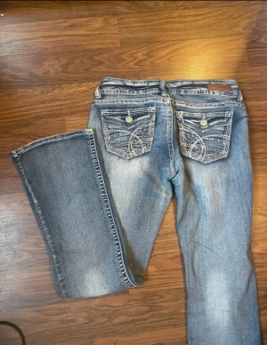 Wallflower blå bootcut jeans - PRIS KAN DISKUTERAS 🩷🩷Snygga blå jeans från Wallflower med bootcut passform och låg midja. Jeansen har slitna detaljer och kontrastsömmar, samt broderade bakfickor med knappar. Materialet är klassisk denim och de har dubbla knappar framtill.