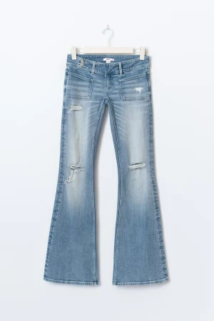 Gina tricot jeans - Snygga bootcut jeans i ljusblå tvätt med slitna detaljer och råa hål på benen. Modellen har låg midja och klassiska fickor fram. Jeansen är tillverkade i mjukt denim-material!! ALDRIG ANVÄNDA SLUTSÅLDA